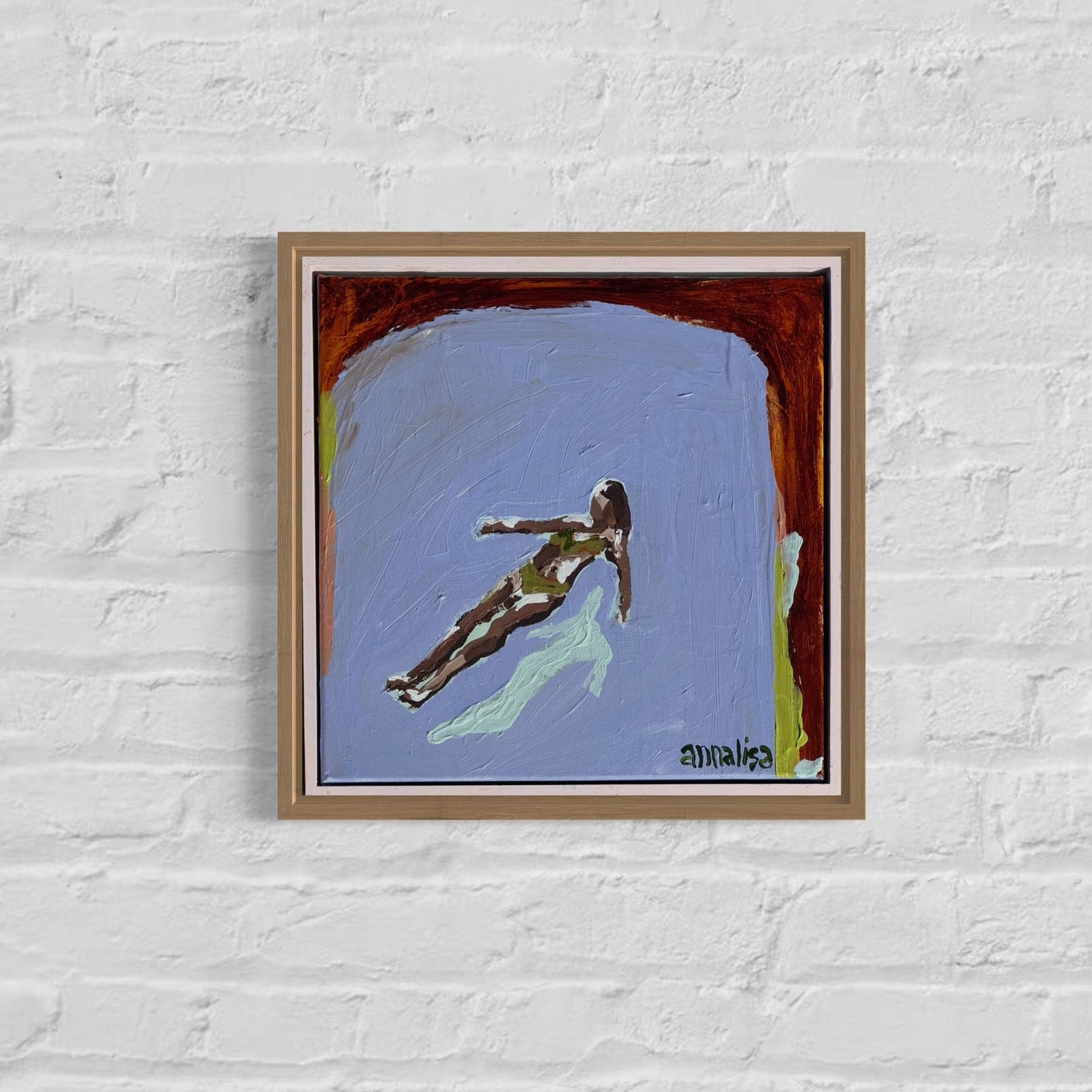 Framed artwork of a person swimming on a white brick wall